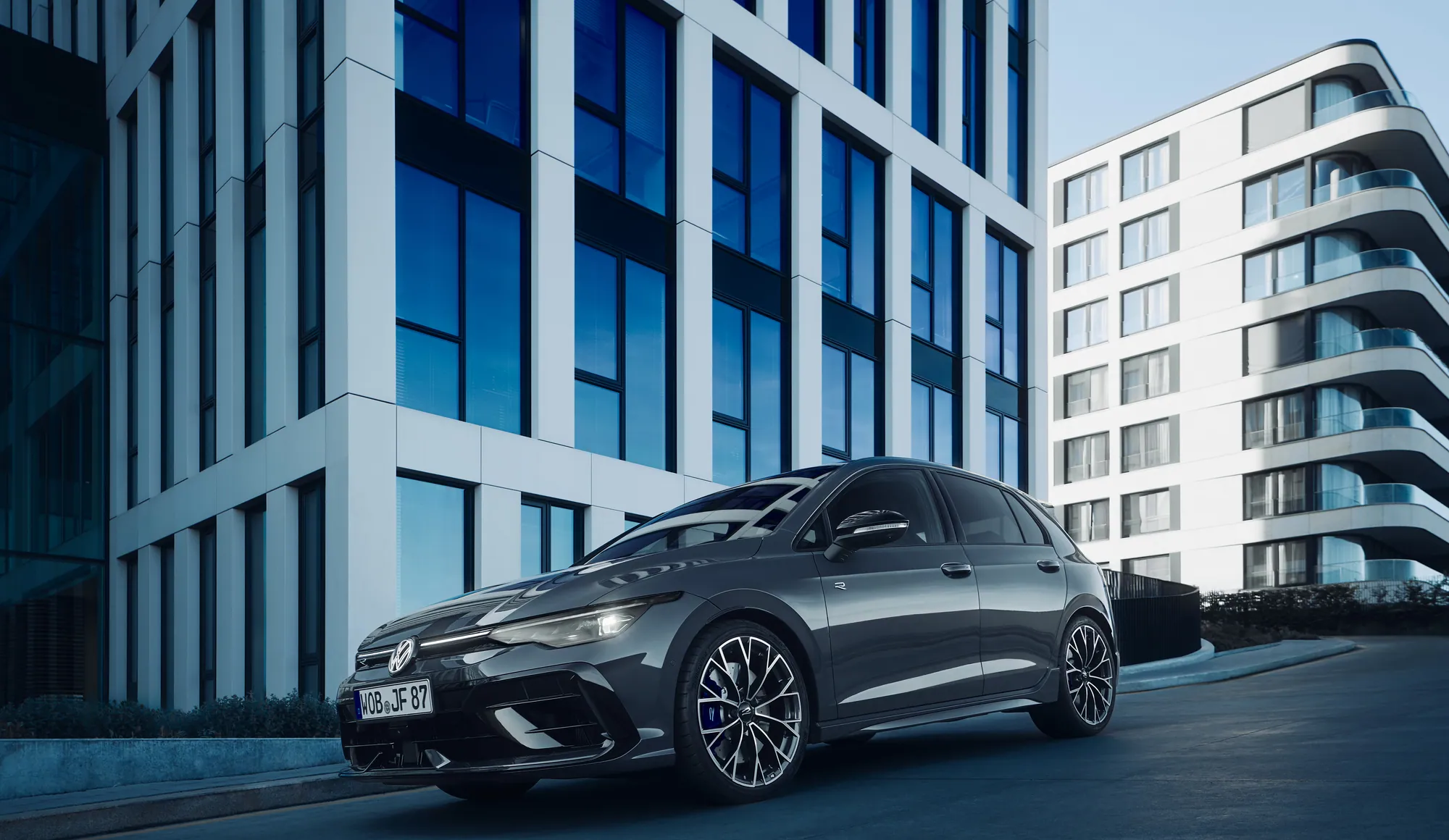Volkswagen Golf R seitlich vor moderner Architektur
